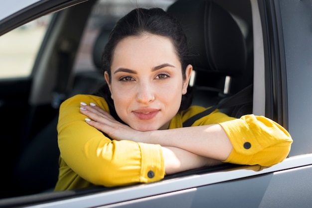 Free photo woman in yellow shirt leaning on the window