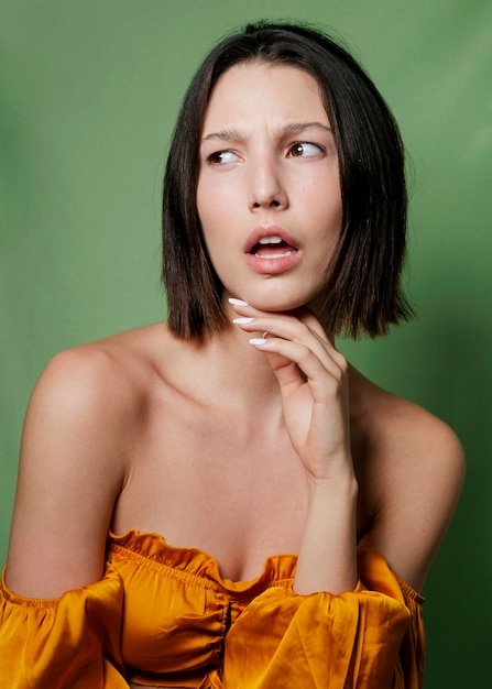 Free photo woman in yellow top posing with hand