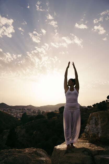 Woman at yoga pose with hands up