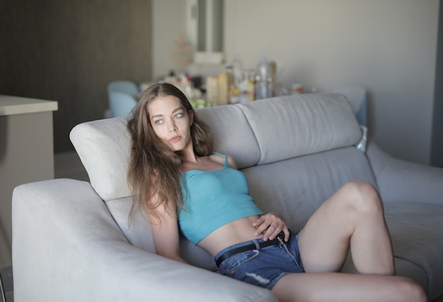 Free photo woman young beautiful woman sitting on the sofa and resting