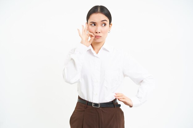 Free photo woman zips her lips makes seal gesture on mouth keeps secret gossips in office white background