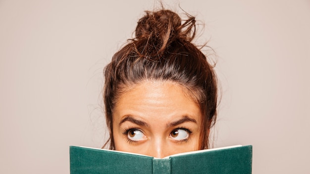 Foto gratuita i womans si trovano dietro un libro