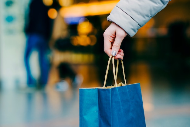 Womans hand holding shopping bag