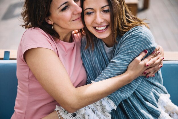 womans hugging on sofa