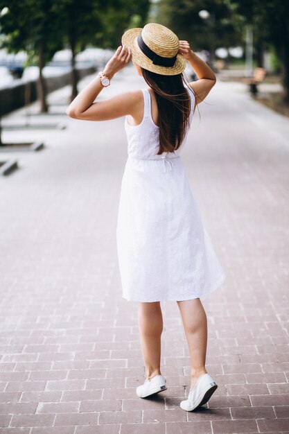 Womanwearing dress and hat outside in park