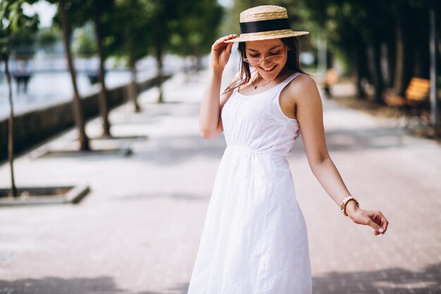 Womanwearing dress and hat outside in park