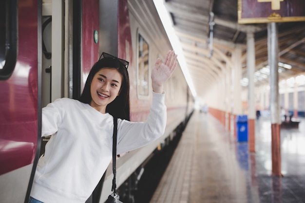 女性は駅で旅行している間幸せです。観光の概念