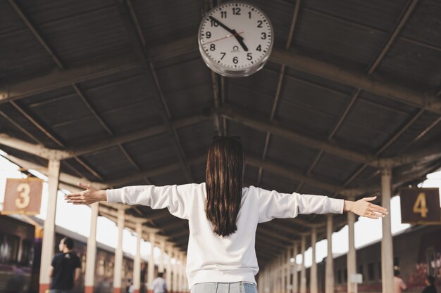 女性は駅で旅行している間幸せです。観光の概念