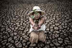 Бесплатное фото Женщины сидят с рассадой, стоят на суше в потеплении мира.