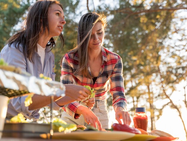 Women arranging delicious food on the table for friends to join