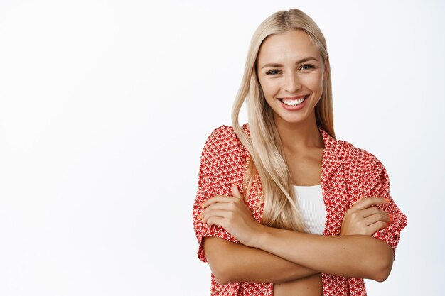 Women beauty and healthcare Young happy smiling woman with blond hair posing with arms crossed against white background