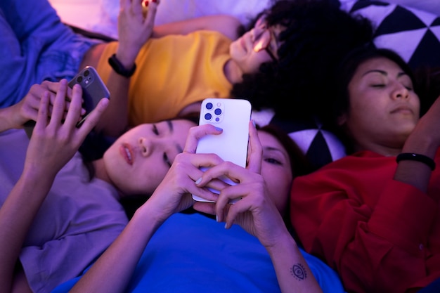 Foto gratuita donne a letto con smartphone ad alto angolo