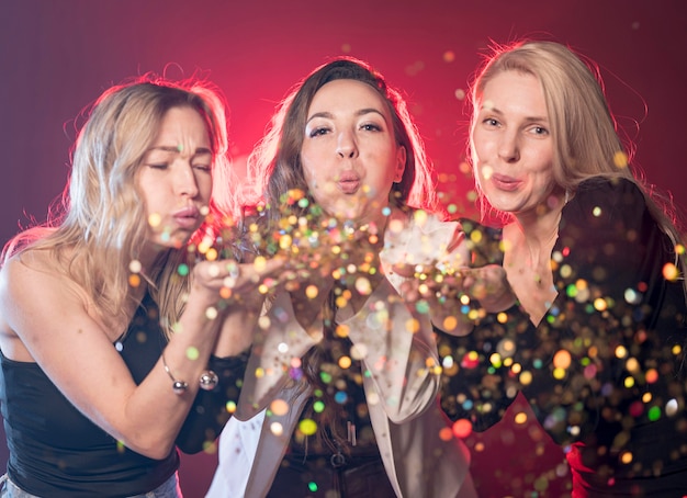 Free photo women blowing glitter