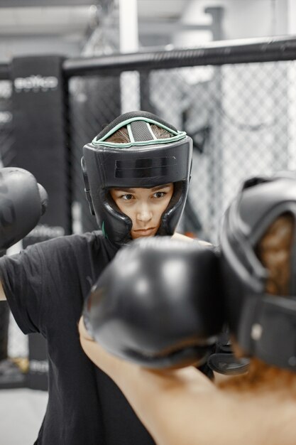 Women boxing. Beginners in a gym. Lady in a black sportwear.