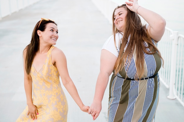 Tenersi per mano delle donne in abbigliamento casual