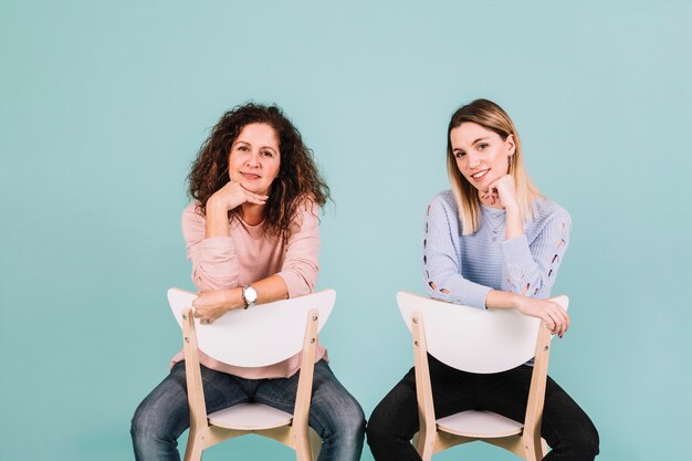 Women on chairs looking at camera