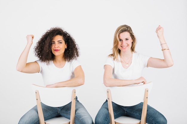 Women on chairs showing muscles