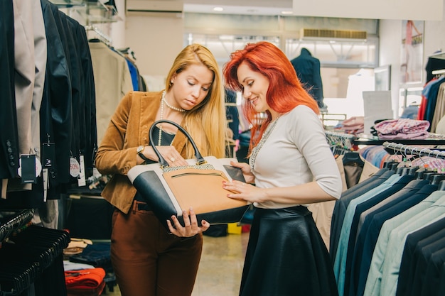 Women choosing bag in shop