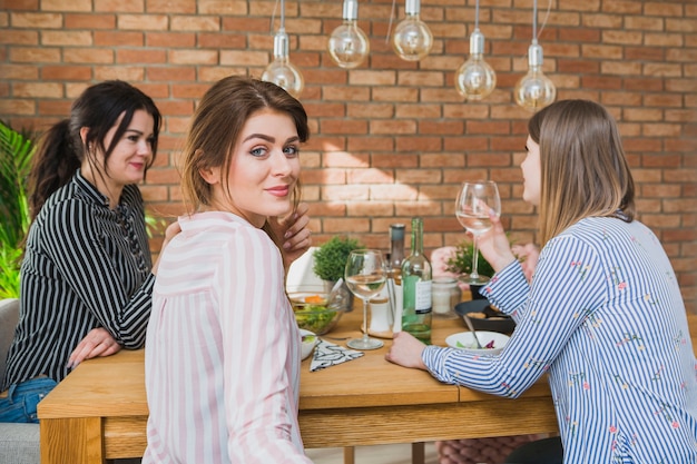 Free photo women in colored shirts sitting at table