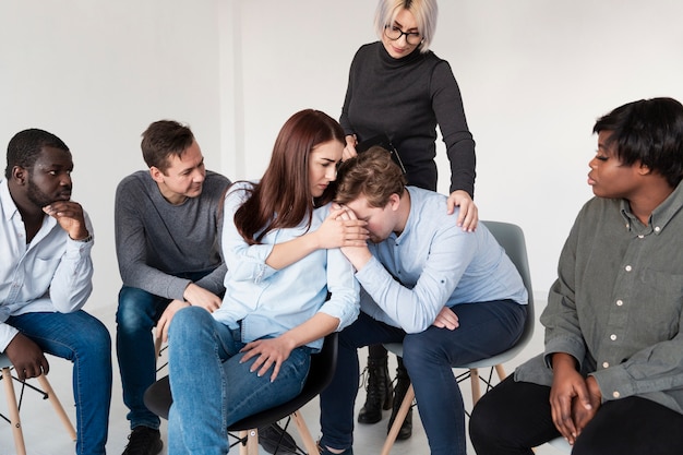 Women consoling male rehab patient