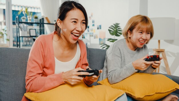 女性のカップルは家でビデオゲームをします。