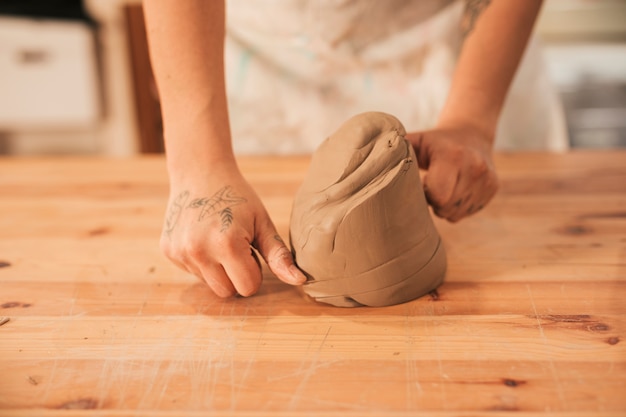 Free photo women cutting the clay with thread on wooden table