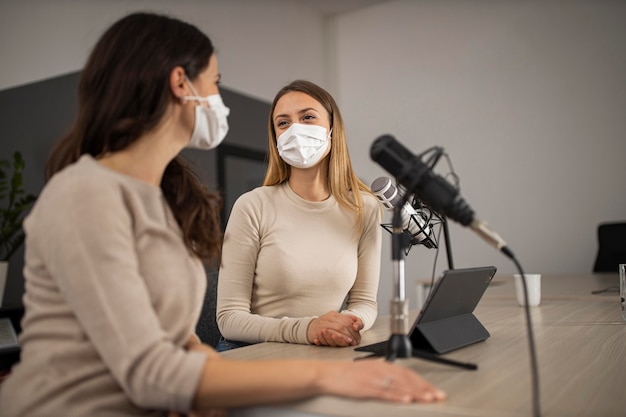 Women doing radio with medical masks on