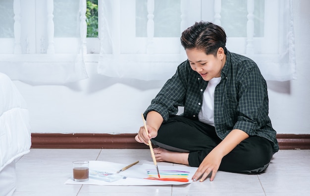 Women draw and paint water on paper.