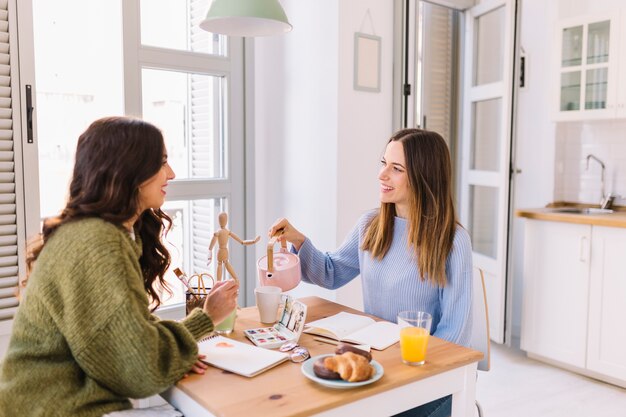 Women drawing and pouring tea