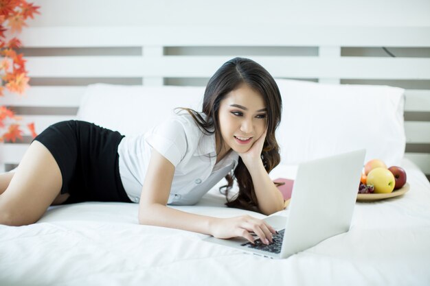 Women dress up student uniforms is watching a movie from a laptop