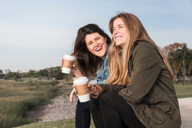 Women drinking coffee on nature background