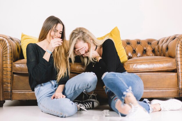 Women drinking near sofa