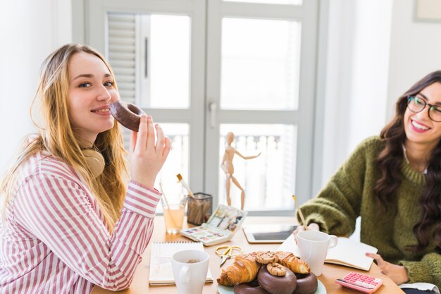 ドローイング中にドーナツを食べる女性