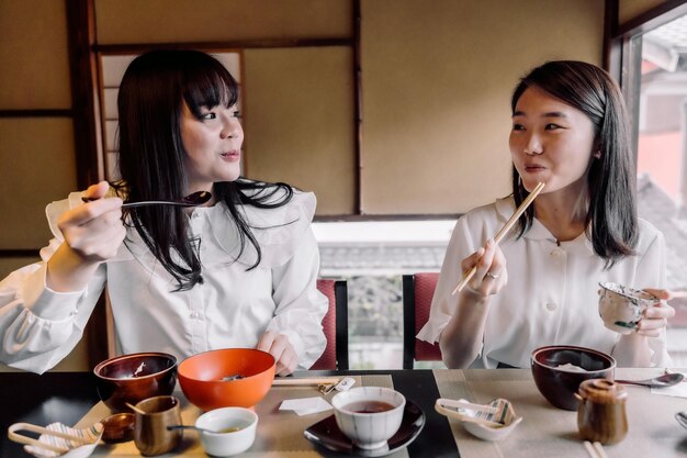 ミディアムショットを一緒に食べる女性