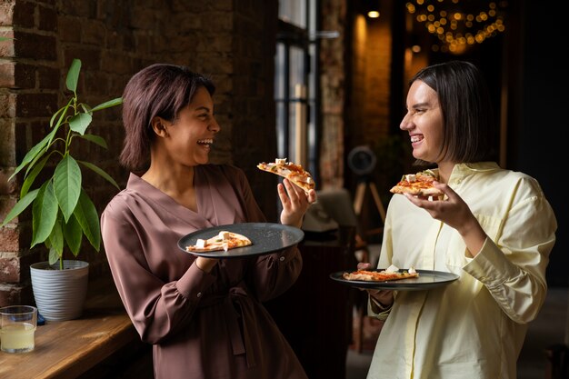 一緒に伝統的なイタリアのピザを食べる女性