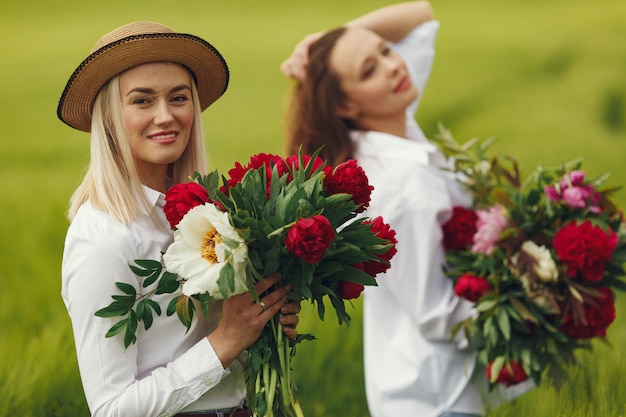 Women in elegant clothes standing in a summer field