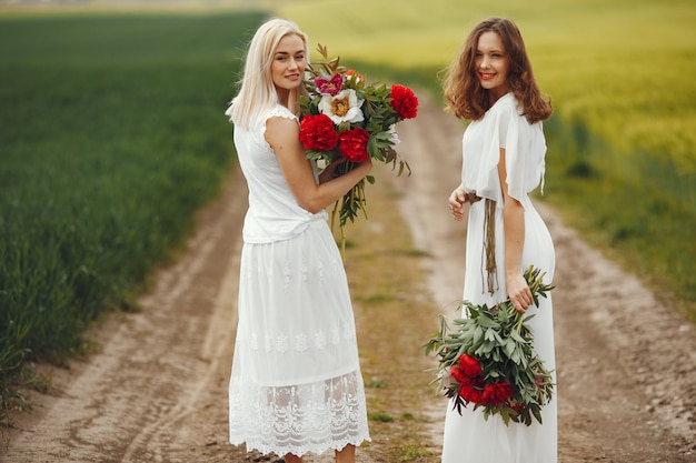 Women in elegant dress standing in a summer field