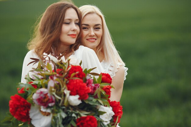 Women in elegant dress standing in a summer field