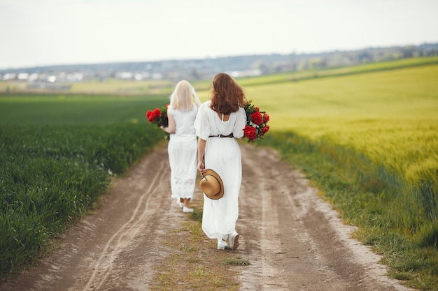 Women in elegant dress standing in a summer field