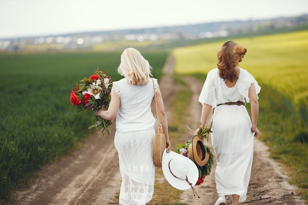 Women in elegant dress standing in a summer field