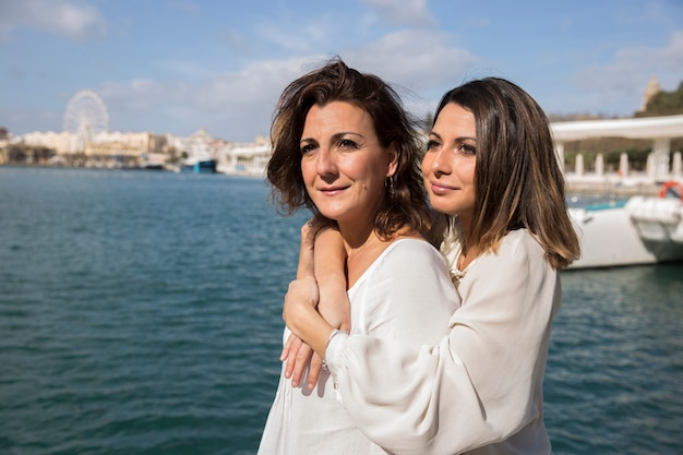 Women embracing near water