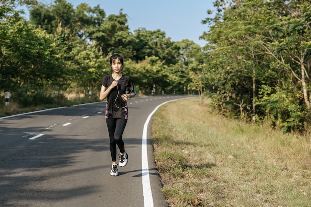 Женщины занимаются бегом по дороге.