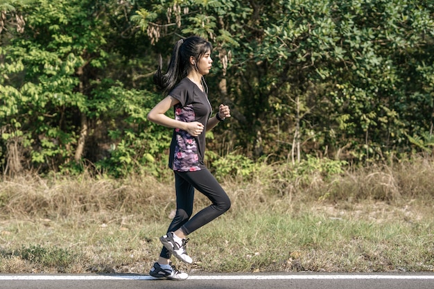 女性は道路を走って運動します。