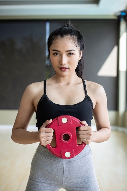 Free photo women exercise with dumbbell weight plates in the chest.