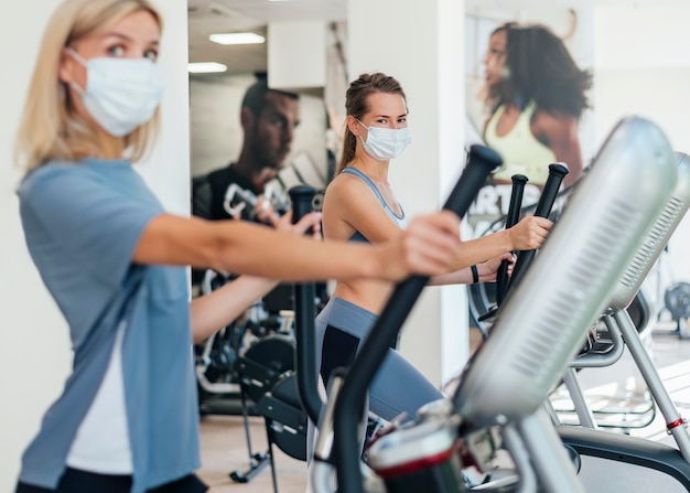 マスクでジムで運動する女性