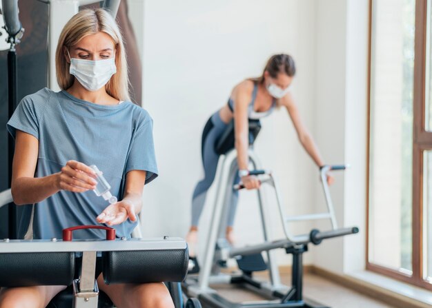 医療用マスクを使用してジムで運動している女性