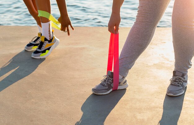 Women exercising with elastic bands by the lake