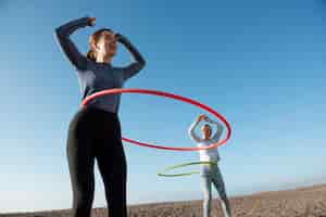 Foto gratuita donne che si esercitano con il cerchio di hula hoop