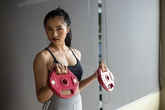 Women exercising with two dumbbell weight plates