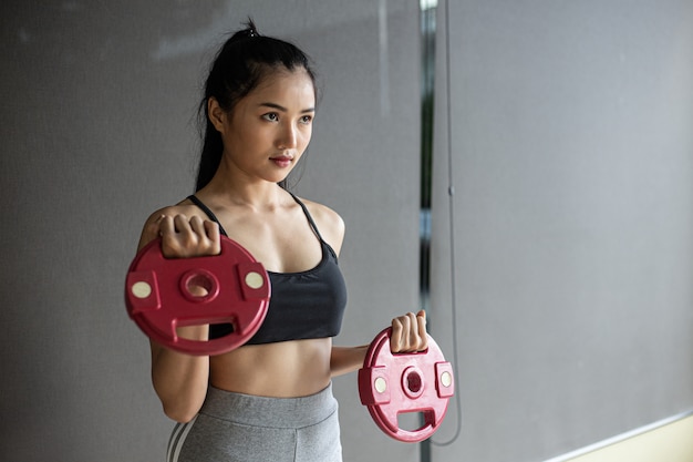 Free photo women exercising with two dumbbell weight plates